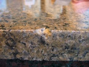 Worn, dull granite edge with a small chip before restoration
